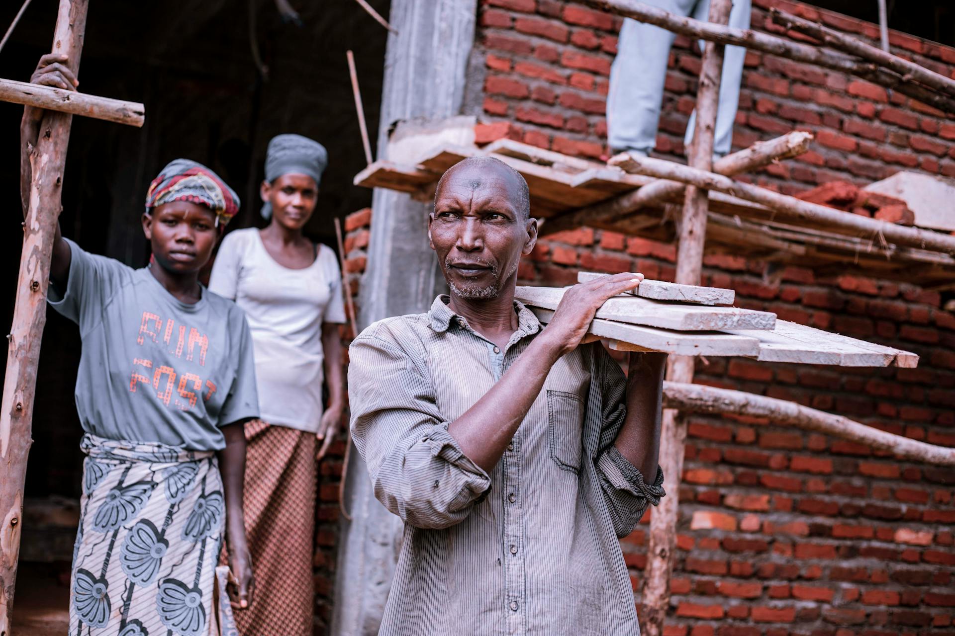 A diverse group of workers actively engaged in construction at a brick building site.