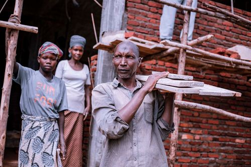 Free A diverse group of workers actively engaged in construction at a brick building site. Stock Photo