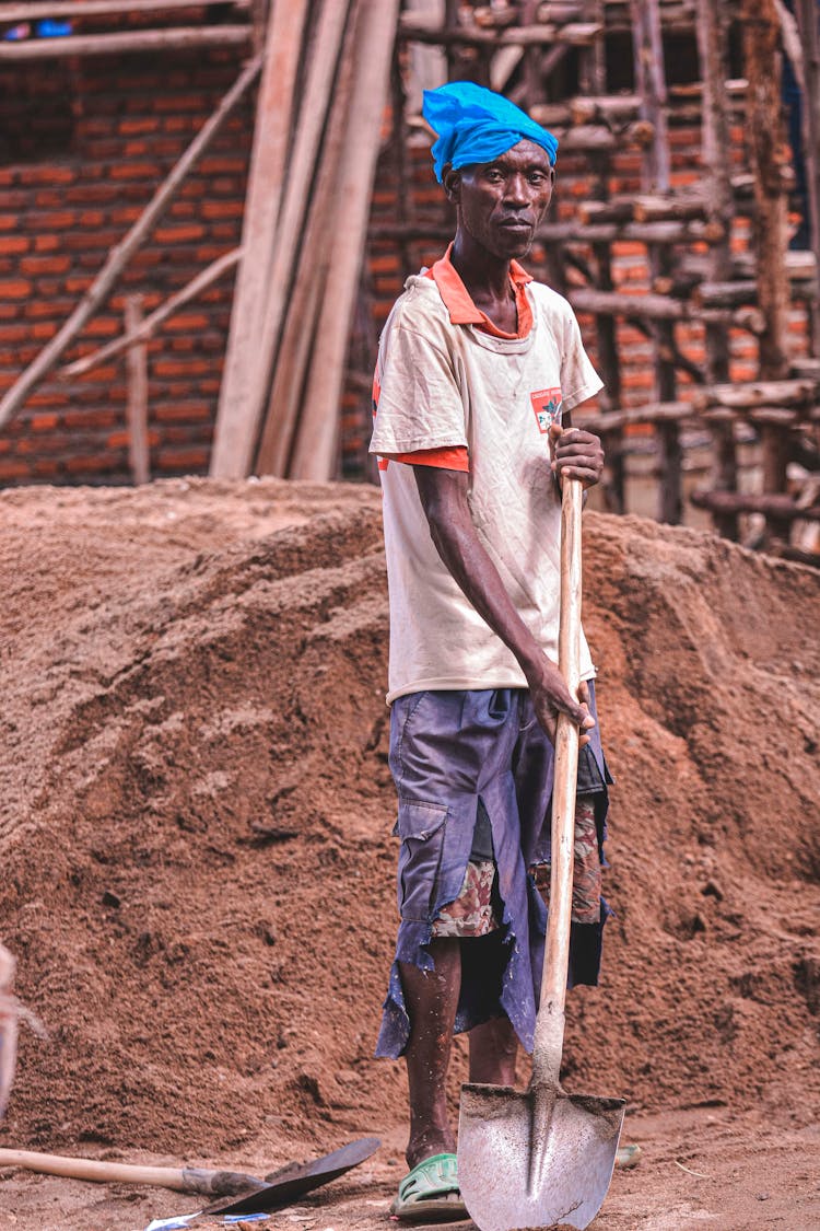 Poor Man With Shovel Working On Construction