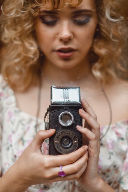 Young woman holding a vintage camera, reflecting nostalgia in São Paulo.