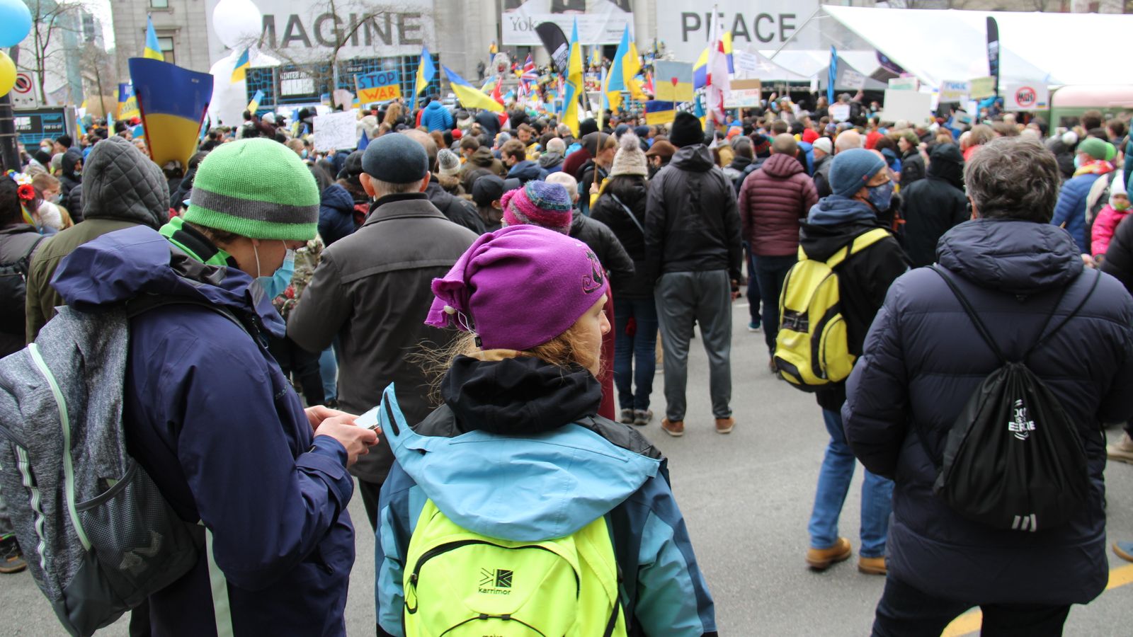 A large crowd gathers in downtown Vancouver for a peaceful protest advocating for peace and unity.