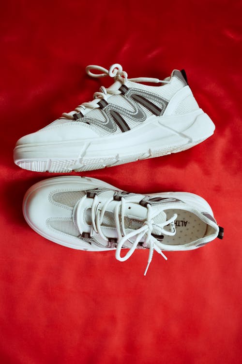 Free White Sneakers on Red Textile Stock Photo