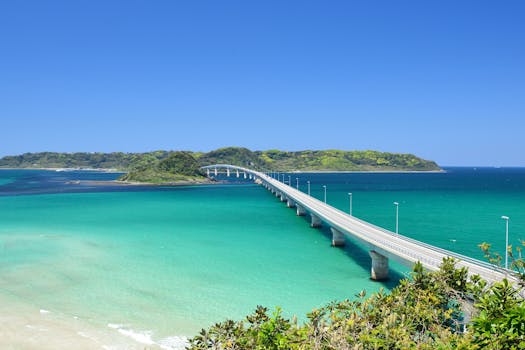 Scenic view of Tsunoshima Bridge spanning turquoise waters in Yamaguchi, Japan under a clear blue sky.