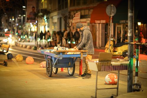 Free Street vendor preparing items on a cart in İstanbul's bustling night scene. Stock Photo