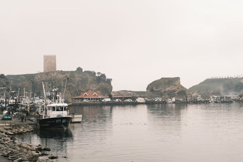 Boats Moored on a Lake By a Castle on a Foggy Day