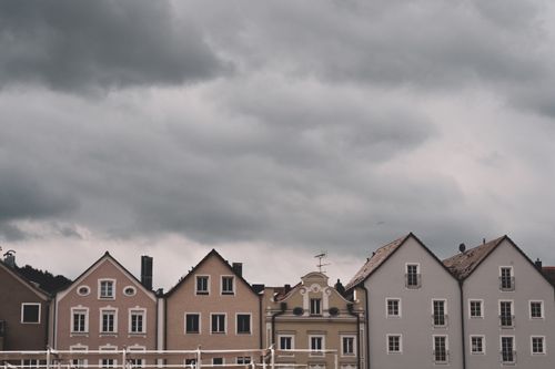 Free Series of picturesque European townhouses with a moody, overcast sky, showcasing unique architectural styles. Stock Photo
