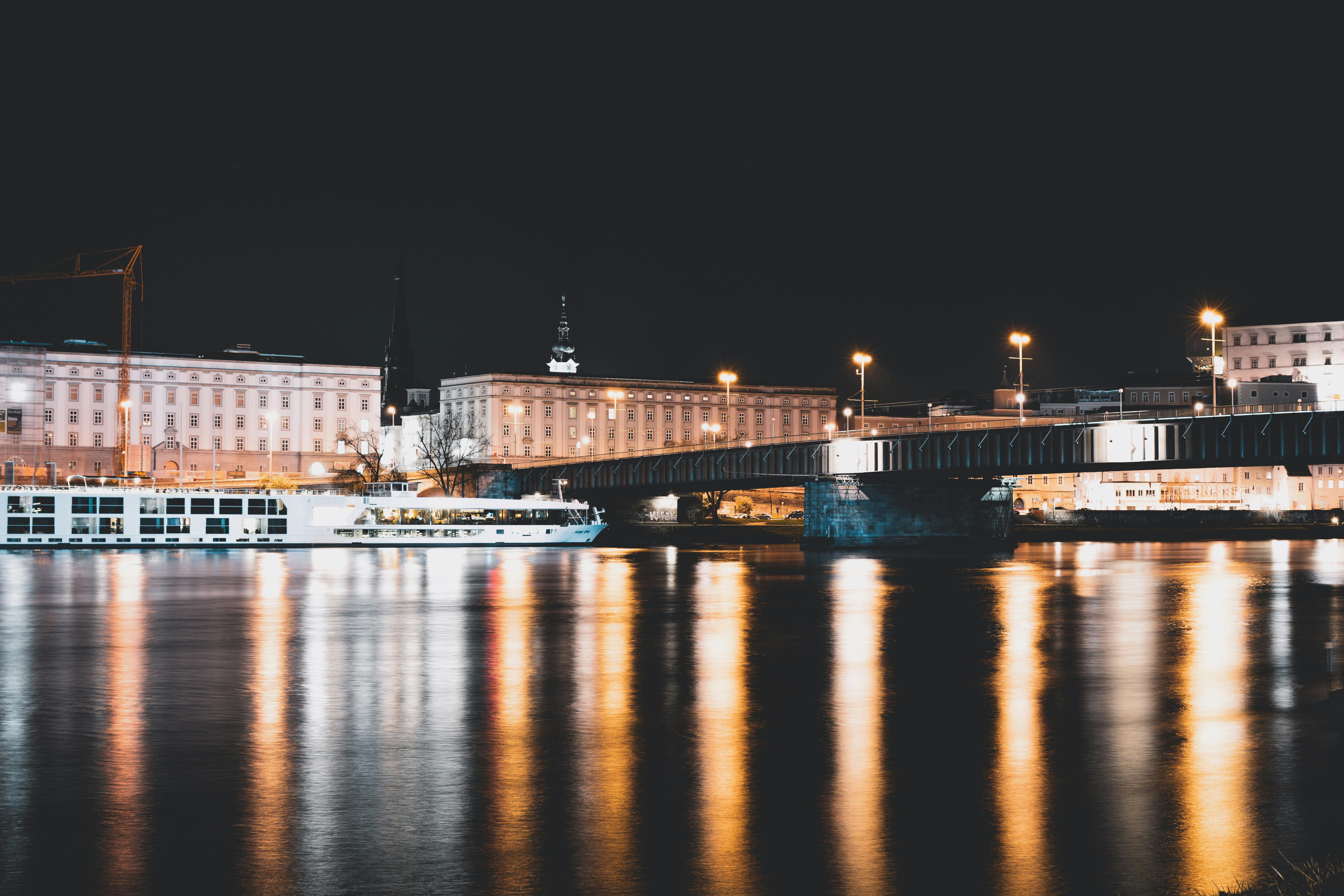 城市桥梁的夜景与建筑物和河流的倒影相映，展现了城市夜间的美丽景色