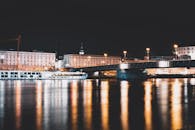 城市桥梁的夜景与建筑物和河流的倒影相映，展现了城市夜间的美丽景色
