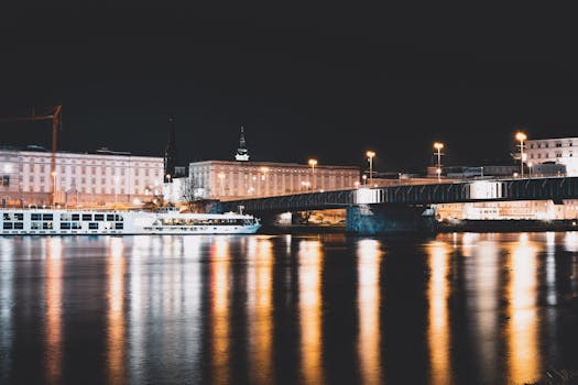 城市桥梁的夜景与建筑物和河流的倒影相映，展现了城市夜间的美丽景色