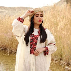 Hand-embroidered cream linen dress — photo by Asal Hoseini on Pexels