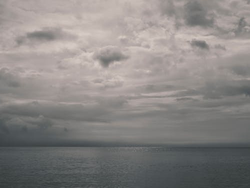 Calm Water in the Sea Under Gloomy Sky