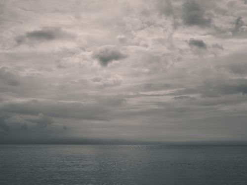 Free A peaceful yet dramatic seascape with an overcast sky, perfect for themes of serenity or contemplation. Stock Photo