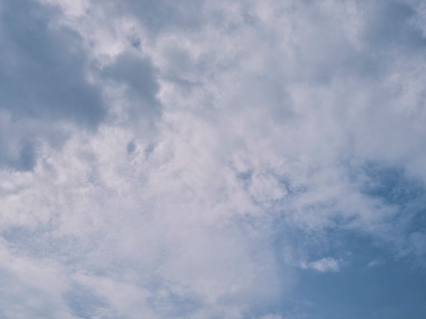 A tranquil cloudscape featuring soft white clouds against a pale blue sky, emitting a peaceful atmosphere.