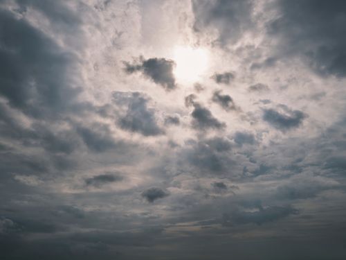 Free A dramatic sky with sun peeking through dark clouds. Ideal for weather themes. Stock Photo