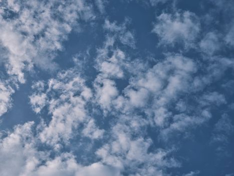 A tranquil blue sky filled with puffy white clouds, perfect for backgrounds or calming visuals.