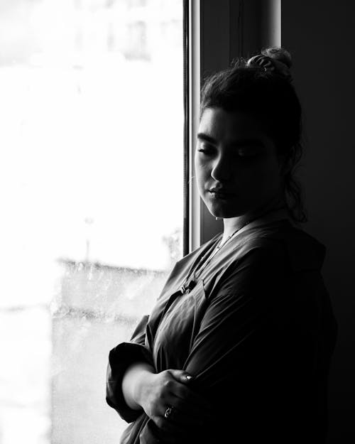 Free A Woman Standing Beside the Window Stock Photo