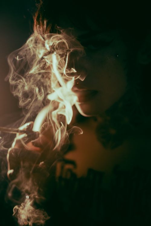 Free Atmospheric portrait featuring a tattooed person enveloped in smoke, creating a moody vibe. Stock Photo