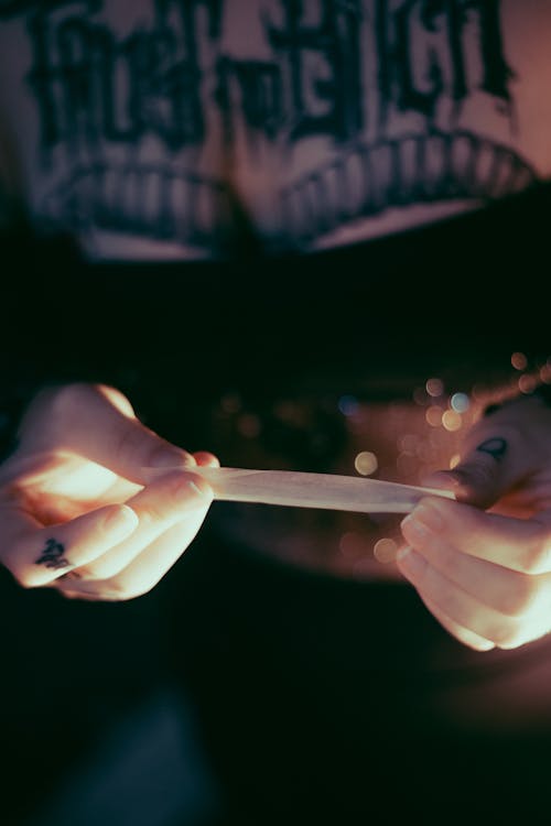 A Tattooed Person Holding a Rolling Paper