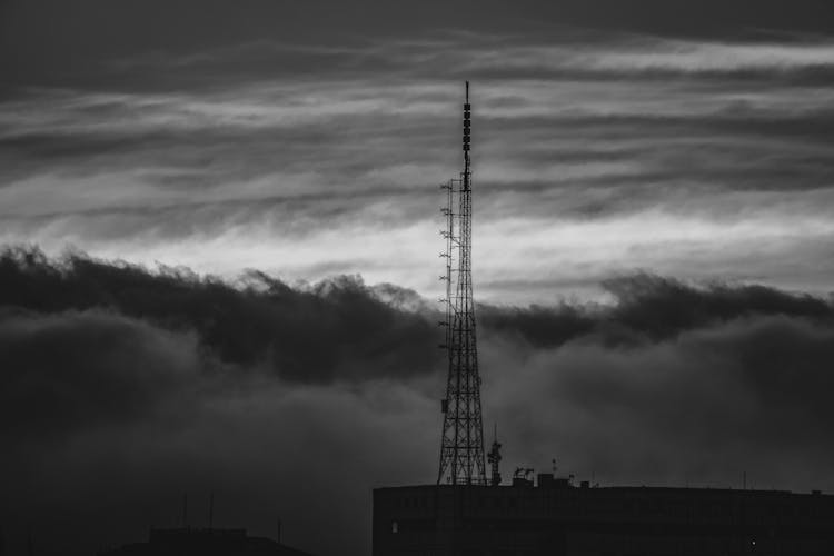 Antenna On Building Roof Against Storm Cloud