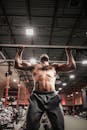 Shirtless Man in Black Jogging Pants Doing Workout in Pull Up Bar