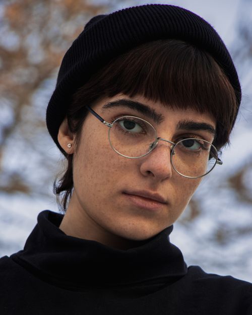 Free Close-up portrait of a woman wearing a beanie and eyeglasses in Tabriz, Iran, exhibiting a serious expression. Stock Photo