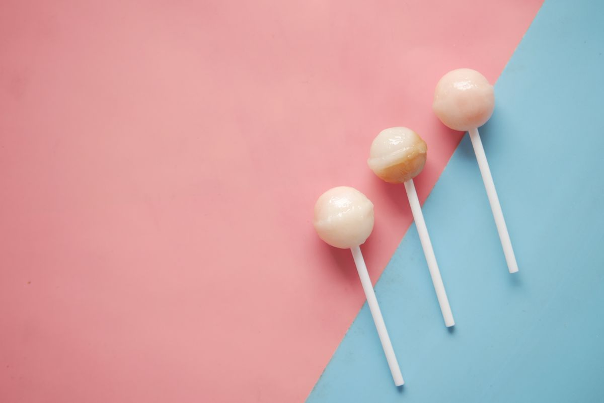Three pastel lollipops arranged on a pink and blue background, providing a sweet and minimal aesthetic.