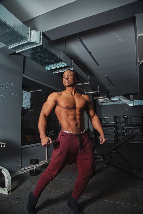 Free A muscular man poses confidently in an indoor gym, showcasing his fit physique. Stock Photo