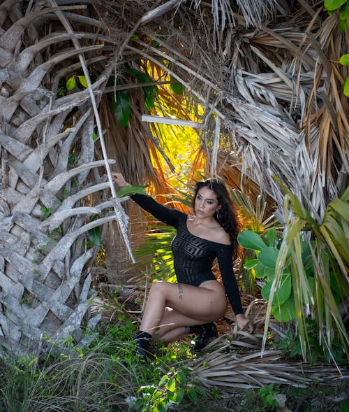 Woman Sitting Among Palm Trees in Miami, Florida