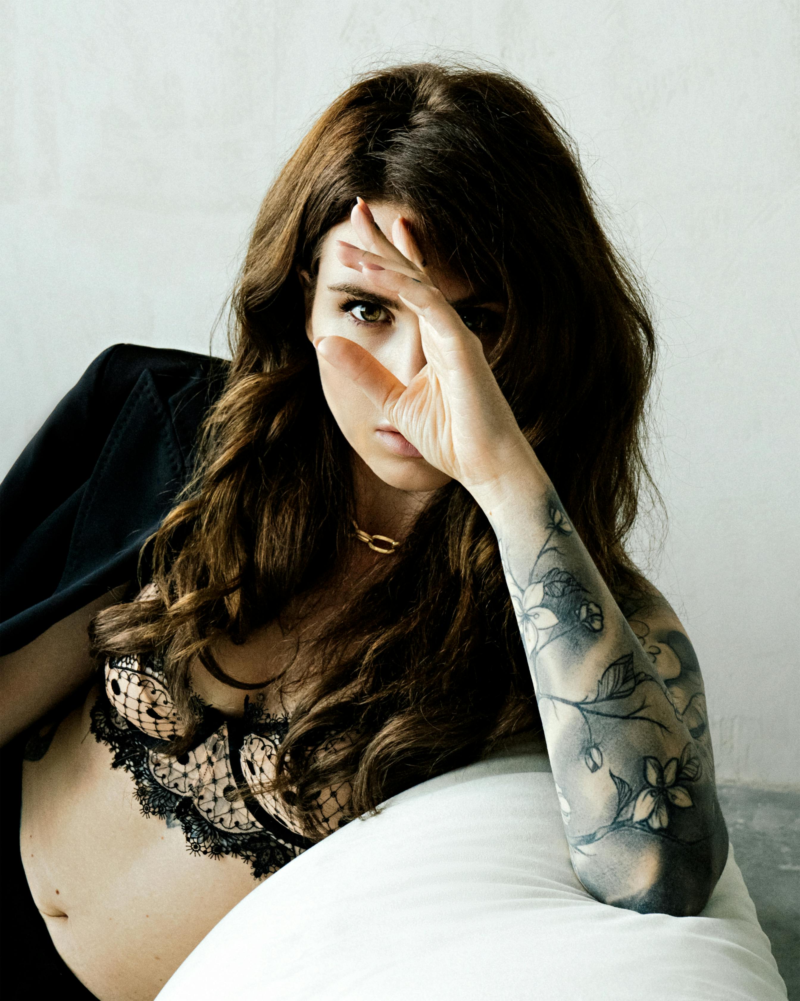 бесплатная Брюнетка с татуировкой на руке позирует в нижнем белье  Стоковое фото