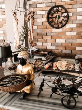 Artistic gourmet buffet setup with statues and culinary elements against a brick wall.