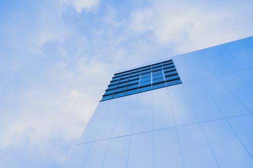 Free Low-angle view of a modern skyscraper facade in London against a blue sky. Stock Photo