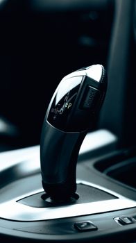 Detailed close-up of a sleek car gear shift lever showcasing modern automotive design.