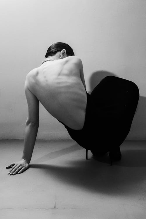 Woman Fashion Model in High Heels ad Long Dress Crouching