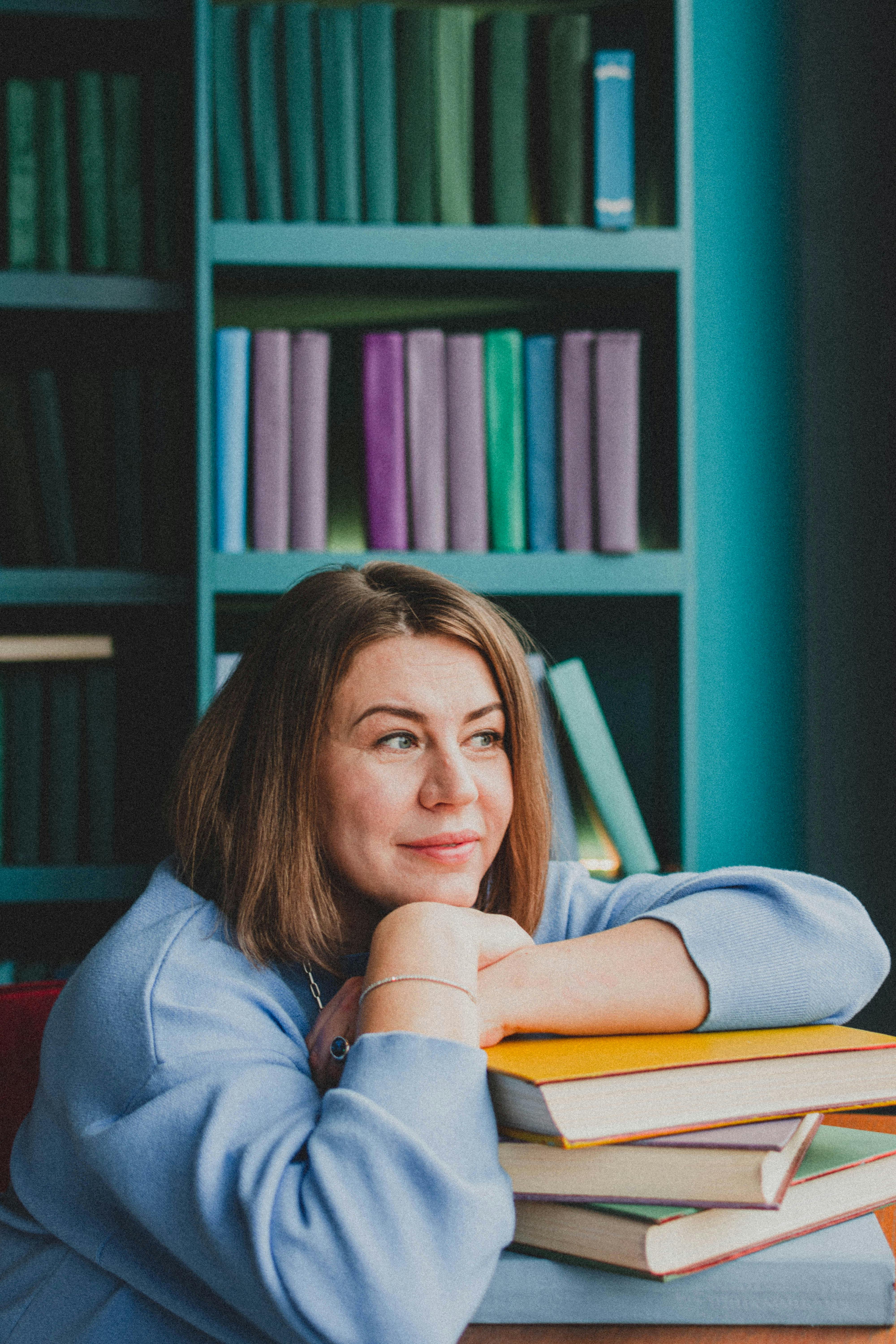 woman resting hands on pile of books