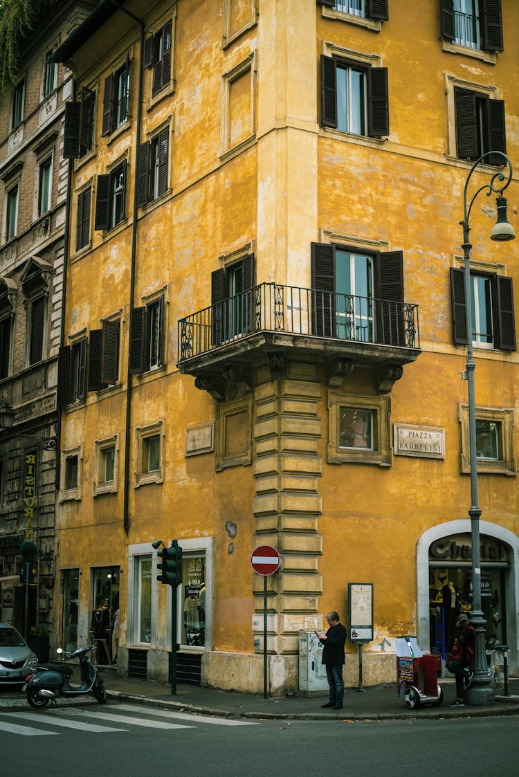 People Standing On The Street Near The Yellow Building