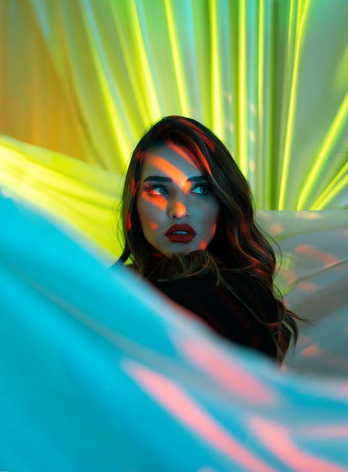 Free Striking portrait of a woman with colorful lighting and red lipstick in Baghdad. Stock Photo