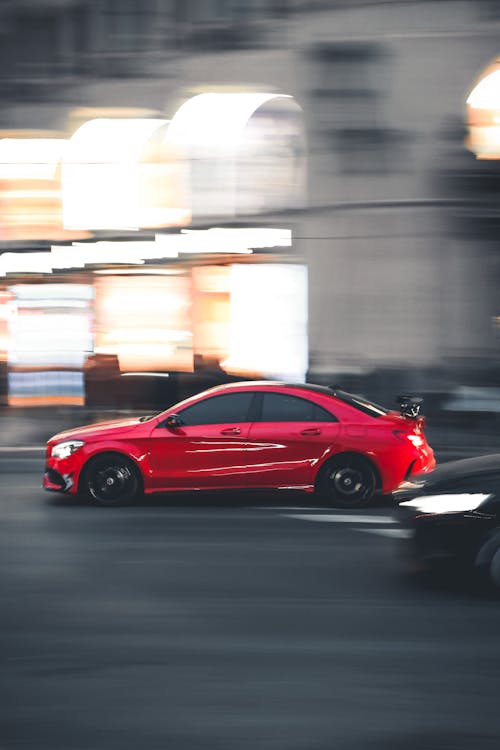 Blurred Image of a Red Car Driving Fast in a City