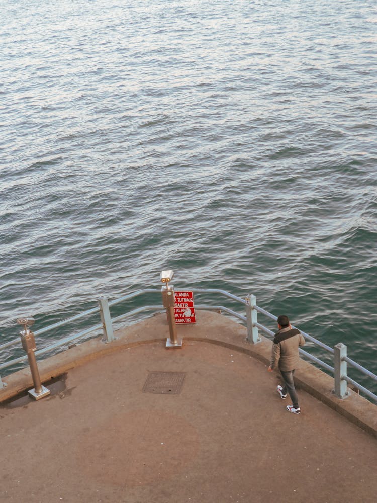 Water Surface And Man On A Pier 