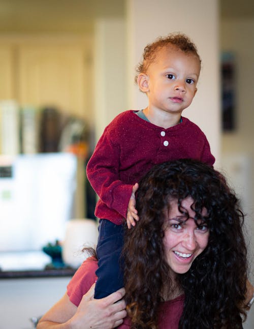 A Woman Carrying Her Son on Her Back