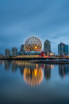 Stunning view of Science World and Vancouver skyline at twilight reflected in the water.