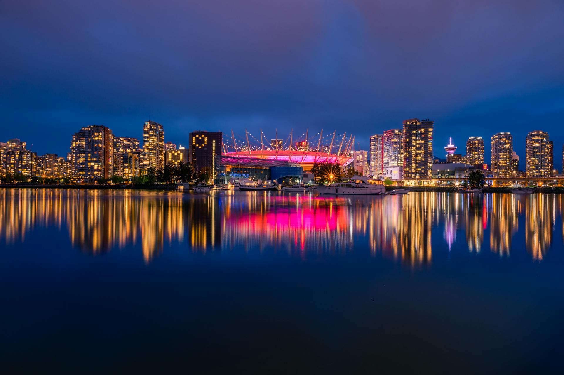 Stunning night view of Vancouver skyline with illuminated BC Place reflected in False Creek.