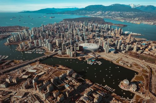 Free Stunning aerial view of Vancouver's cityscape, showcasing skyscrapers and coastal mountains. Stock Photo