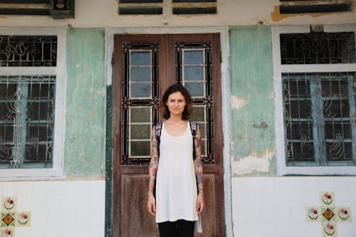 Free A Woman Standing in Front of the Doorway Stock Photo