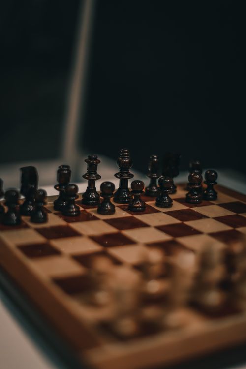 Free Close-up of chess pieces on a wooden board, strategic game setup. Stock Photo