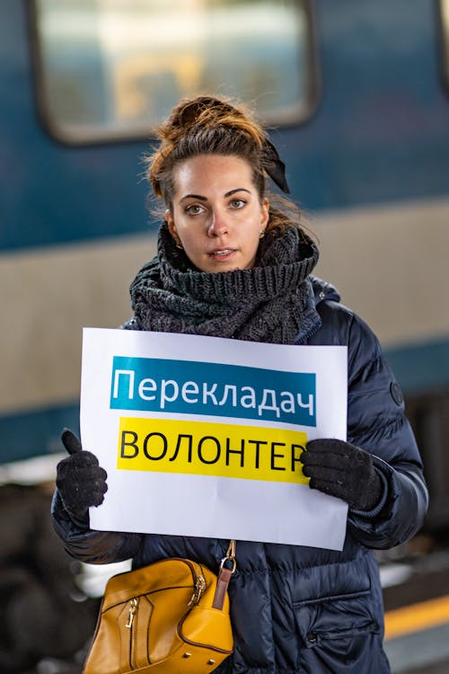A Woman in Black Jacket Holding a Placard
