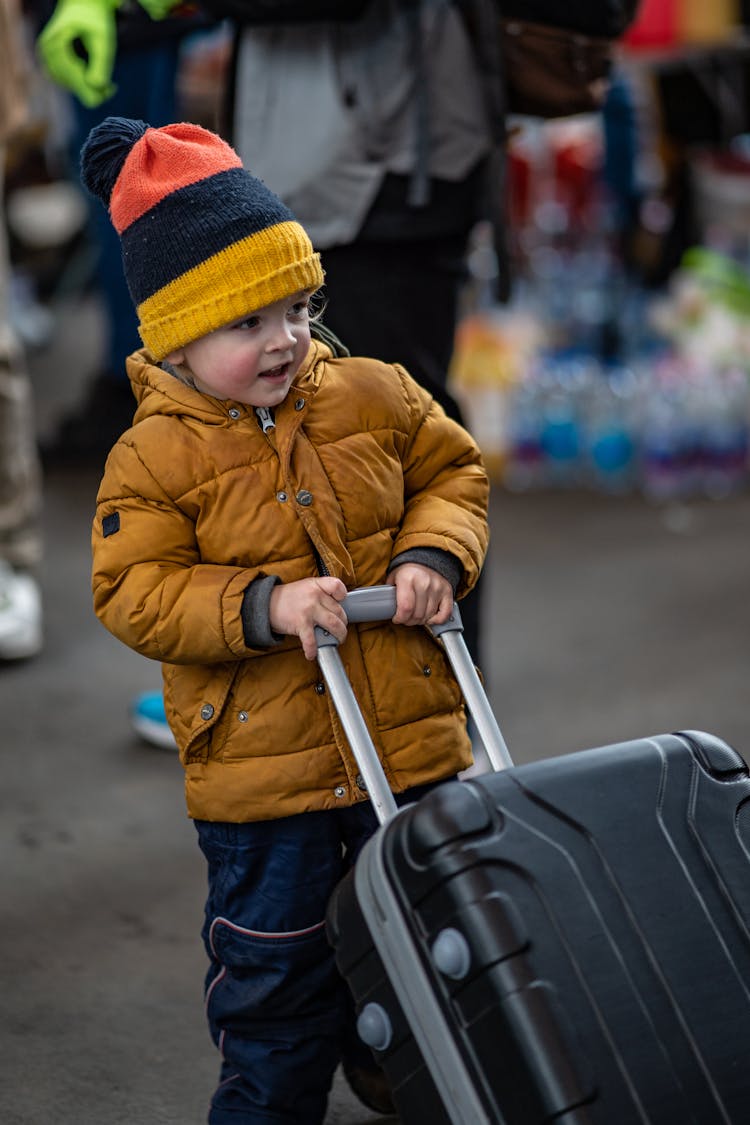 A Child Pulling A Suitcase