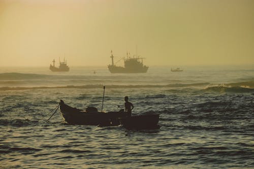 Free Silhouette of Man Fisherman on a Boat  Stock Photo