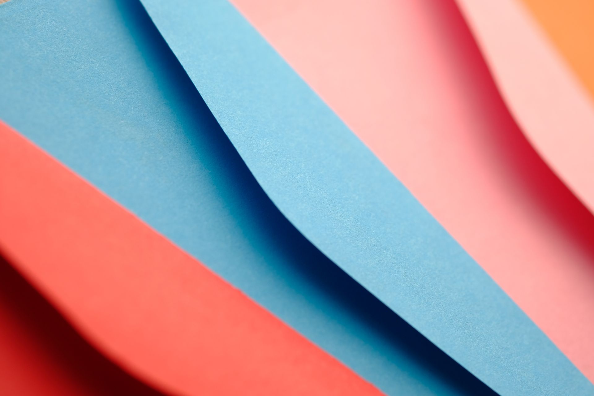 Vibrant abstract composition of colorful paper edges in close-up, showcasing texture and color contrast.