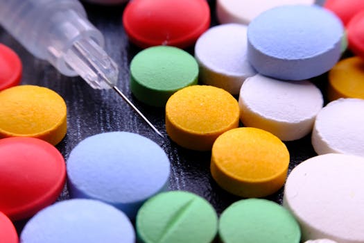 Vibrant close-up of assorted pills and a syringe needle.