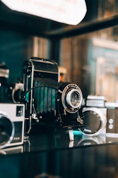 A collection of vintage cameras, including film and rangefinder models, displayed in an antique shop.